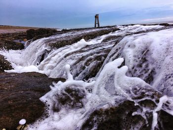 Scenic view of waterfall against clear sky during winter