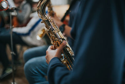 Midsection of saxophonist playing saxophone