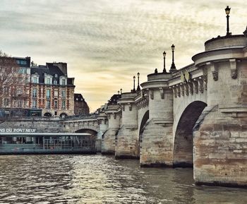 View of bridge over river against cloudy sky