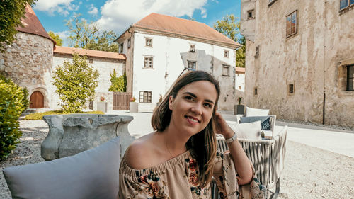Portrait of happy young woman inside a castle courtyard.
