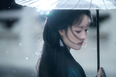 Portrait of young woman with umbrella