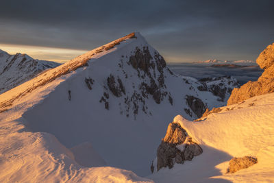 Scenic view of snowcapped mountains against sky during sunset