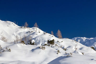 Snow covered mountains against clear blue sky