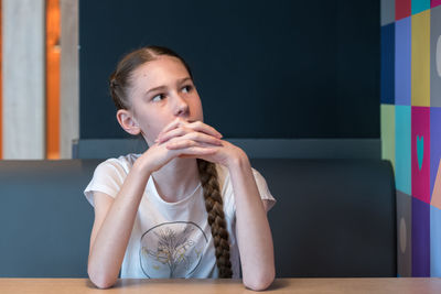 Portrait of a young woman sitting on table