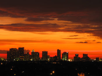 Illuminated buildings against sky during sunset