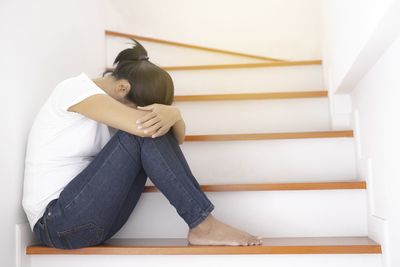 Woman sitting on staircase at home