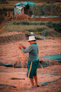 Rear view of man working on field