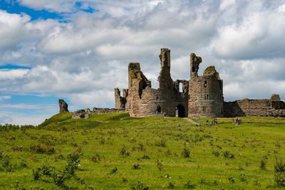 Old ruins on field against sky