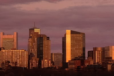 Skyscrapers in city at sunset