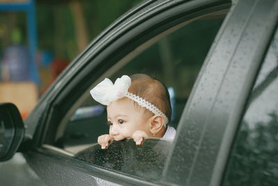 Portrait of boy looking through car windshield
