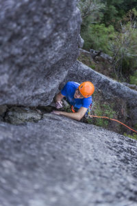 Man starting to climb wide crack on granite during multipitch climb