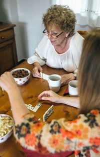 Close-up of family playing dominoes while having food at table