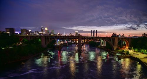 Bridge over river in city at night