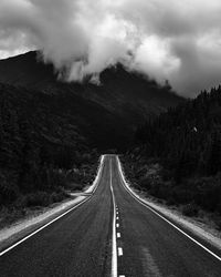 Road leading towards mountain against sky