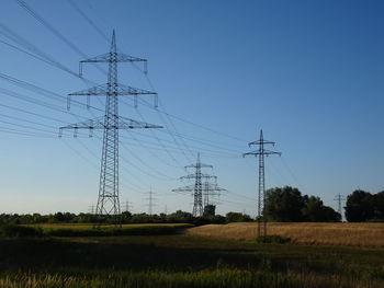Power poles and power cables as elements of the landscape. electricity pylon against clear blue sky 