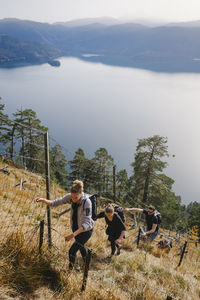 High angle view of friends hiking steep mountain