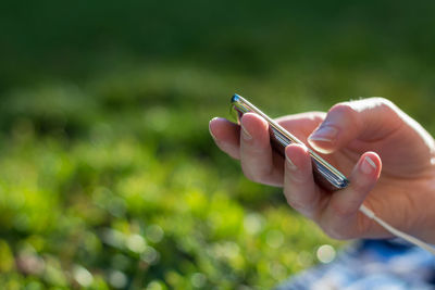 Cropped hand of person holding mp3 player 