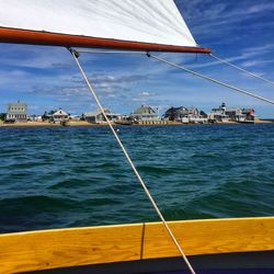 Sailboat in calm sea against blue sky