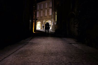 Silhouette couple walking in dark alley