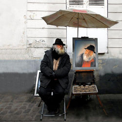 Man and woman standing on wet umbrella