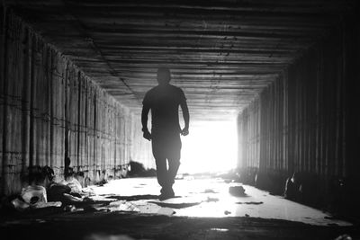 Silhouette man walking in corridor of building