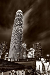 Low angle view of illuminated buildings against cloudy sky