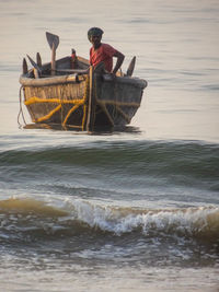 Fisherman sitting on boat at sea