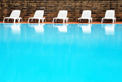 White lounge chairs at poolside