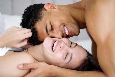 Young interracial couple  in bed smiling 