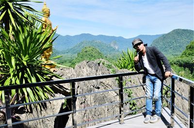 Mature man wearing sunglasses standing against landscape during sunny day