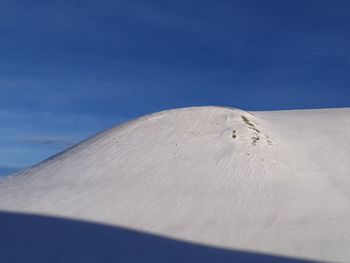 Low angle view of desert against blue sky