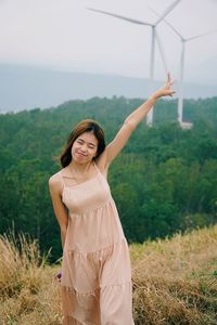 Portrait of smiling young woman standing on field