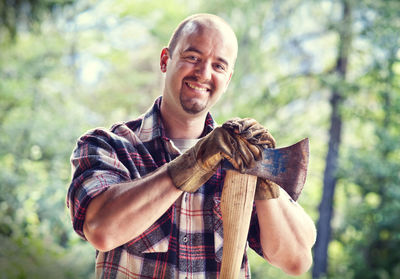 Portrait of smiling man holding axe