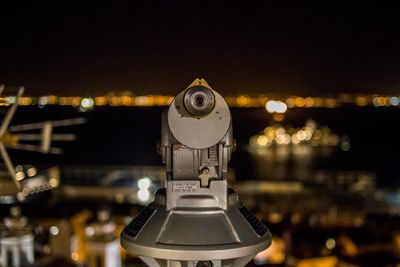 Close-up of illuminated lighting equipment against sky at night