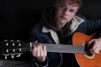 Portrait of young man playing guitar