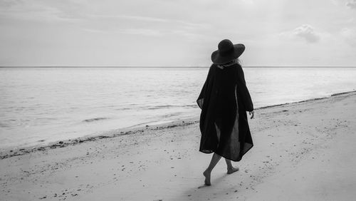 Woman on beach against sky