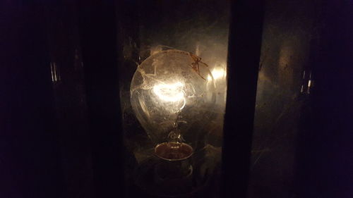 Close-up of illuminated light bulb in darkroom