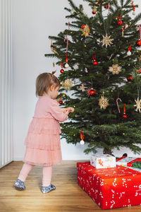 Girl playing with christmas tree