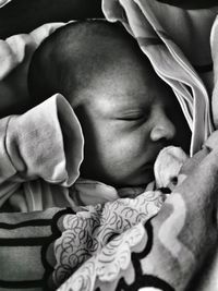 Close-up of newborn baby boy sleeping on bed