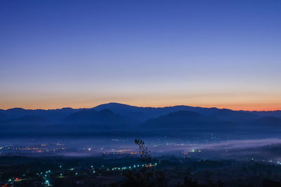 Scenic view of silhouette mountains against clear sky at sunset