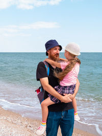 Happy father daughter walking marine landscape. bearded dad child in hands having fun together 