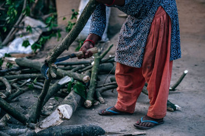 Low section of woman cutting branches in village