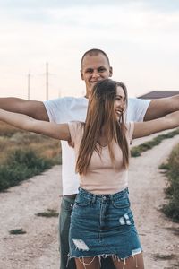 Happy woman with arms raised against the sky