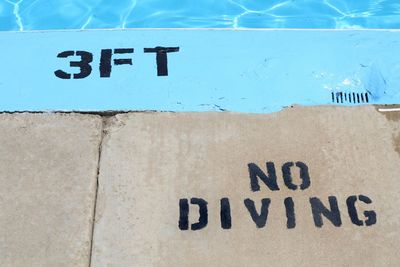 High angle view of no diving sign at poolside