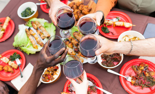 Close up of glasses of red wine and details group dinner friend -