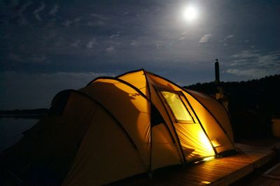 Illuminated tent against sky at sunset