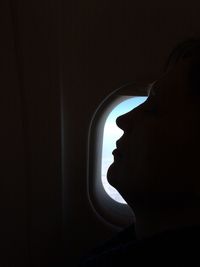 Side view of silhouette man against airplane window