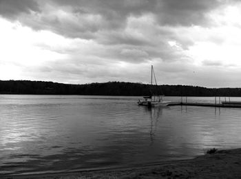 Sailboats moored on lake against sky