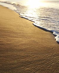 Close-up of sand at beach against sky