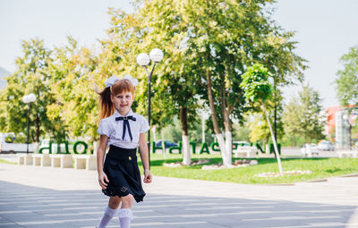 A little girl elementary school student is having fun walking down the street.